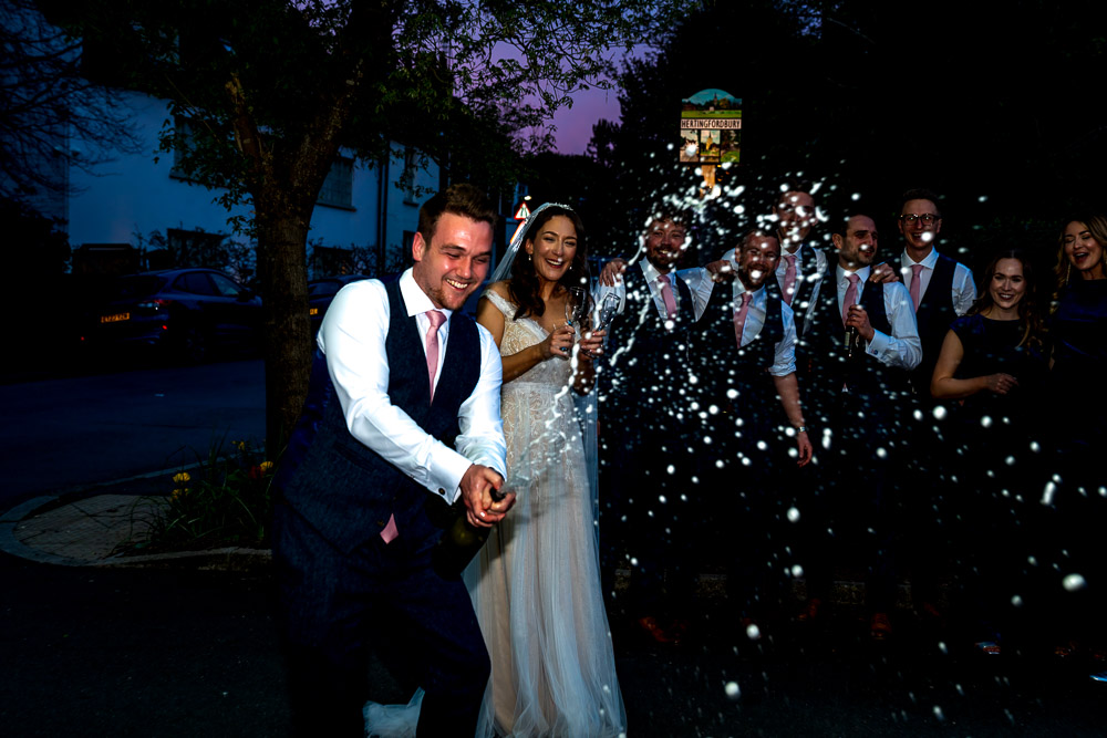 An enhanced image of the groom spraying champagne, his bride and groomsmen can be clearly seen in the backgrouond