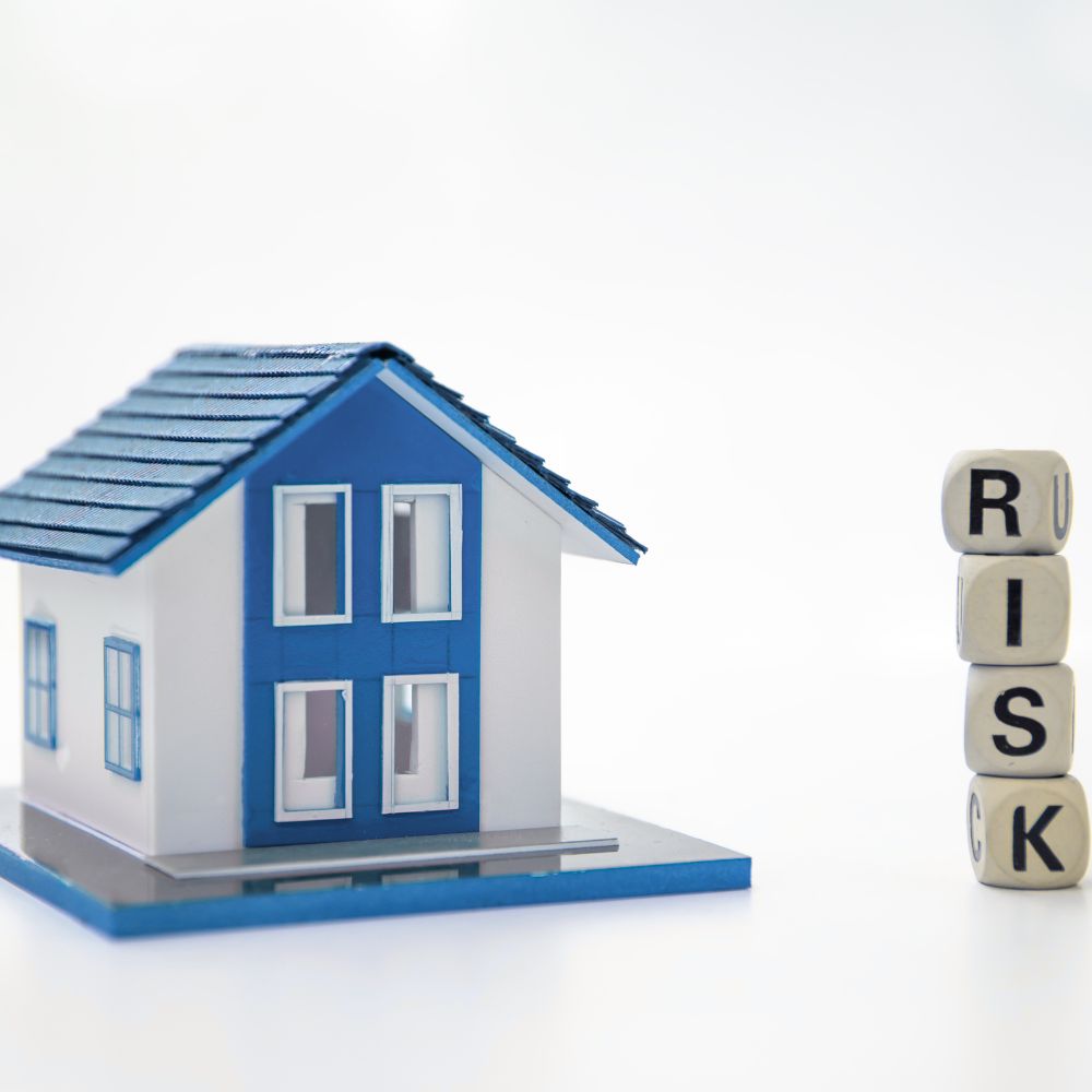 A volatile mortgage market represented by a model house with a blue roof, door and windows and 4 blocks stacked to spell the word RISK